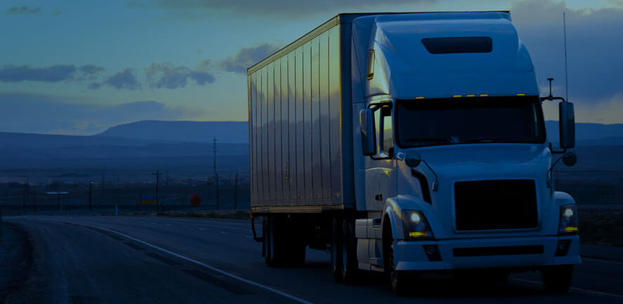 18-wheeler in the distance with sunset behind. Milwaukee truck accident lawyer | Cannon & Dunphy, S.C. 