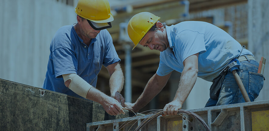 two construction workers in hard hats working outside 